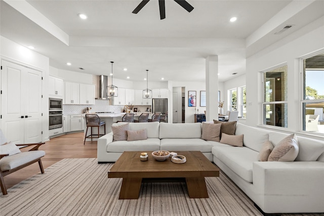 living room with recessed lighting, visible vents, ceiling fan, and light wood-style flooring