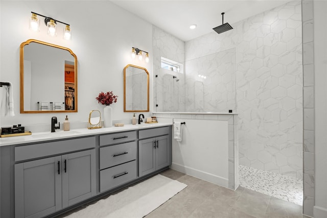 bathroom featuring a walk in closet, double vanity, a sink, and a walk in shower