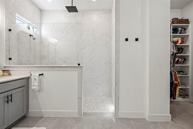 bathroom with tiled shower and vanity