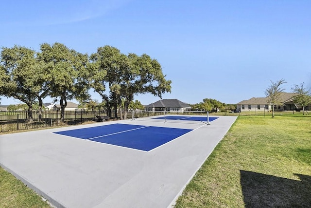 exterior space featuring a tennis court, a yard, fence, and a residential view