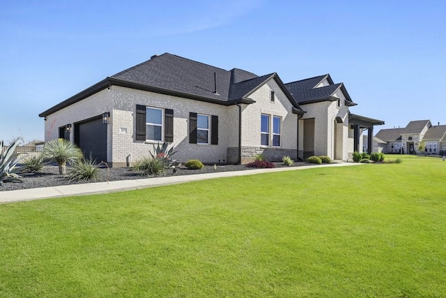 view of front of house featuring a garage, brick siding, a front lawn, and roof with shingles