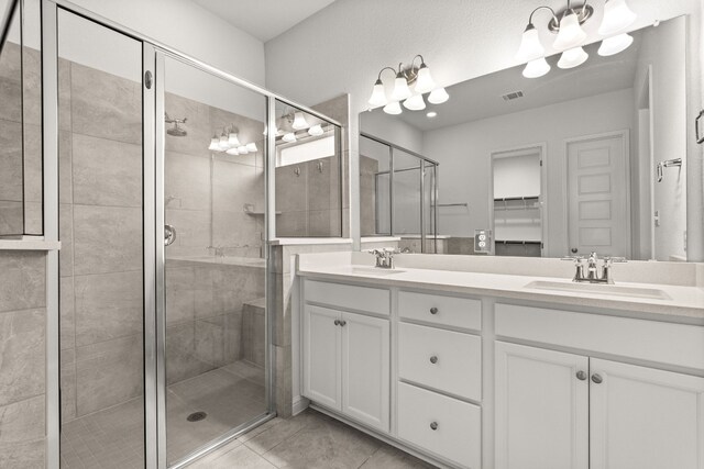 1813 Arapaho Mountain Pass, Leander, TX 78641 - full bath featuring a stall shower, double vanity, tile patterned floors, and a spacious closet