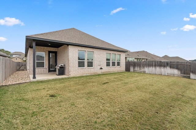 1813 Arapaho Mountain Pass, Leander, TX 78641 - back of house with brick siding, a patio, a shingled roof, and a fenced backyard