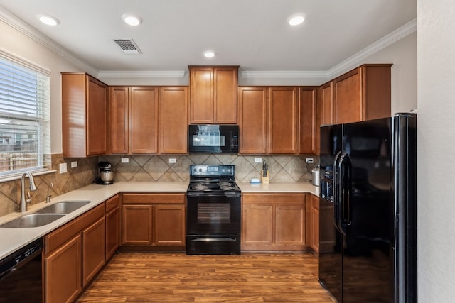 kitchen featuring black appliances, crown molding, sink, hardwood / wood-style flooring, and tasteful backsplash