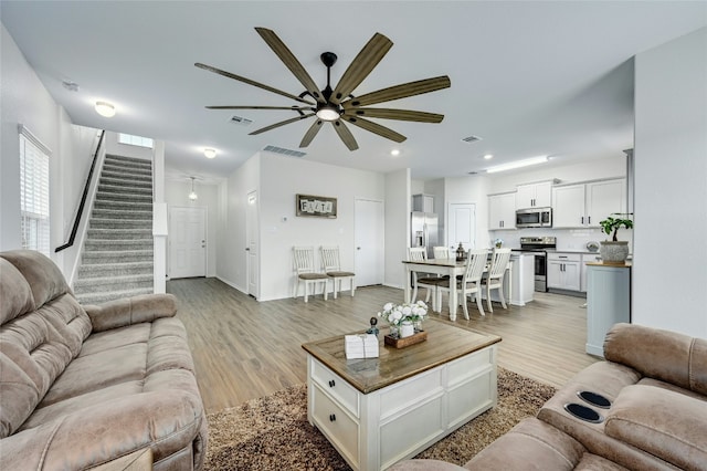 213 Bronco Billy Dr, Jarrell, TX 76537 - living area with a ceiling fan, stairs, light wood-type flooring, recessed lighting, and baseboards