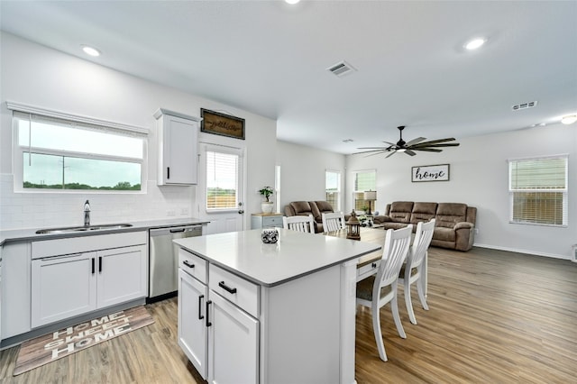 kitchen with white cabinetry, dishwasher, a center island, and sink