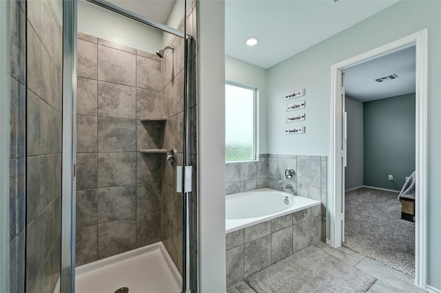 bathroom with tile patterned flooring and shower with separate bathtub