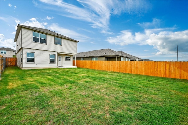 rear view of property with a yard