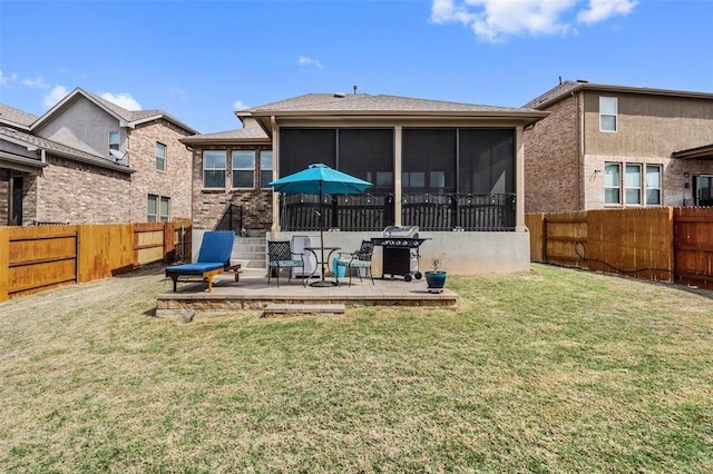 rear view of property featuring a lawn, a sunroom, and a patio