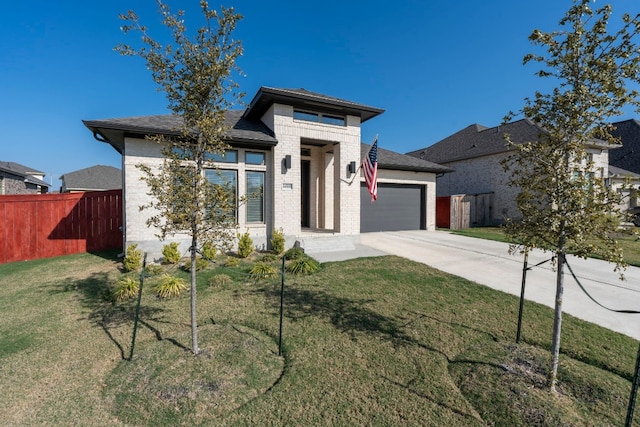 prairie-style home with a garage and a front lawn