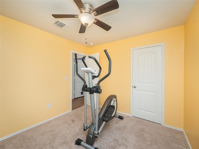 exercise area with ceiling fan and light colored carpet