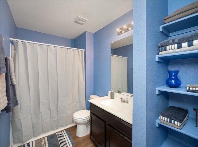 bathroom with hardwood / wood-style flooring, vanity, and toilet