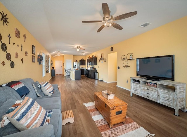 living room featuring ceiling fan, dark wood-type flooring, and lofted ceiling