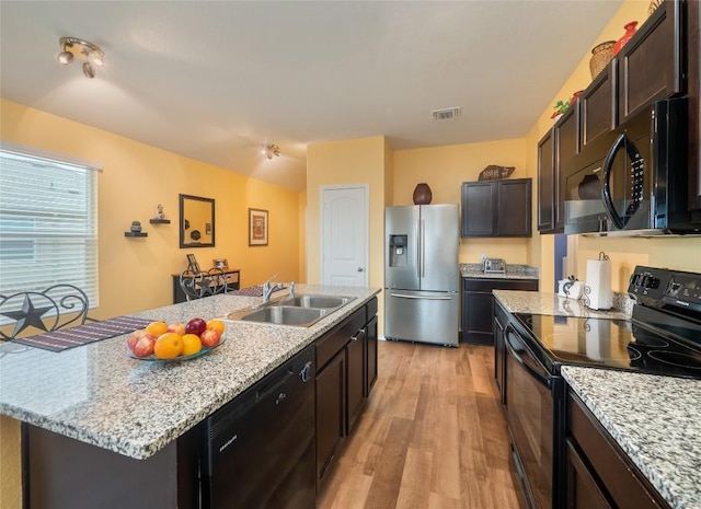 kitchen featuring black appliances, sink, light wood-type flooring, an island with sink, and dark brown cabinets