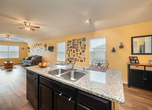 kitchen with dishwasher, an island with sink, light hardwood / wood-style flooring, and sink