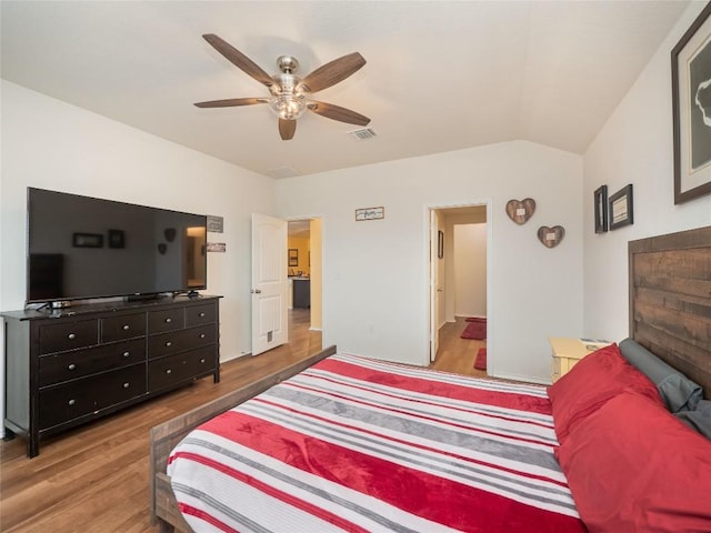 bedroom with hardwood / wood-style floors, vaulted ceiling, and ceiling fan