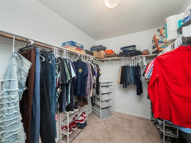 walk in closet featuring light carpet