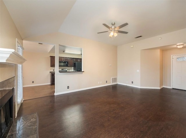 unfurnished living room featuring ceiling fan, dark hardwood / wood-style flooring, a premium fireplace, and vaulted ceiling