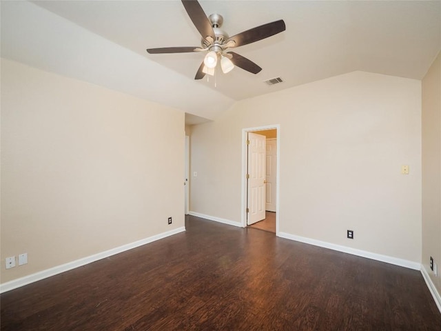 empty room featuring vaulted ceiling, ceiling fan, and dark wood-type flooring