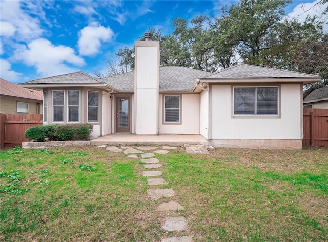 rear view of house featuring a lawn and a patio area