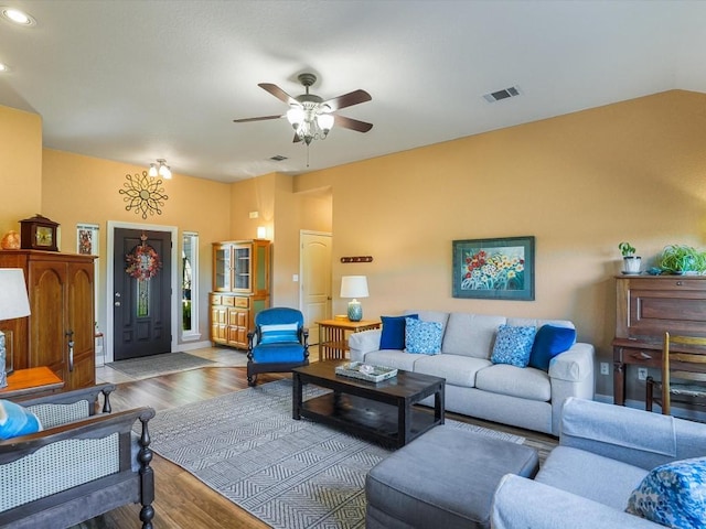 living room featuring ceiling fan, lofted ceiling, and light wood-type flooring