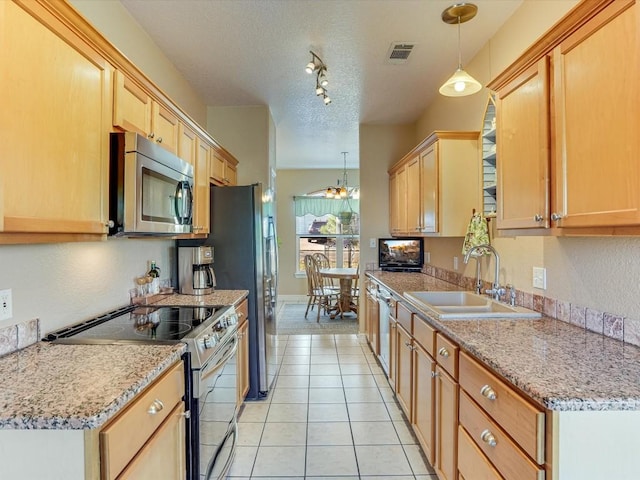 kitchen featuring sink, a textured ceiling, decorative light fixtures, light tile patterned floors, and appliances with stainless steel finishes