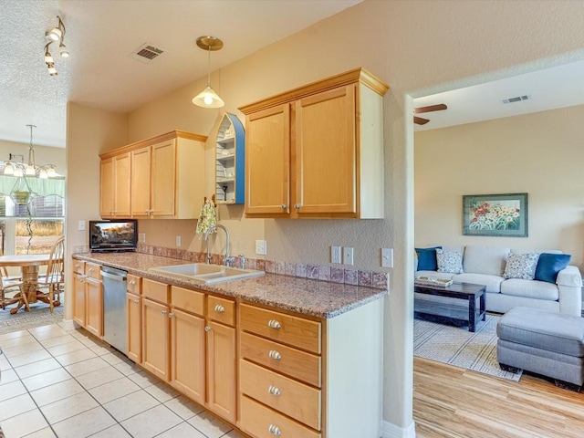 kitchen with a textured ceiling, sink, light brown cabinets, decorative light fixtures, and dishwasher