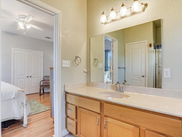 bathroom featuring hardwood / wood-style flooring, ceiling fan, and vanity