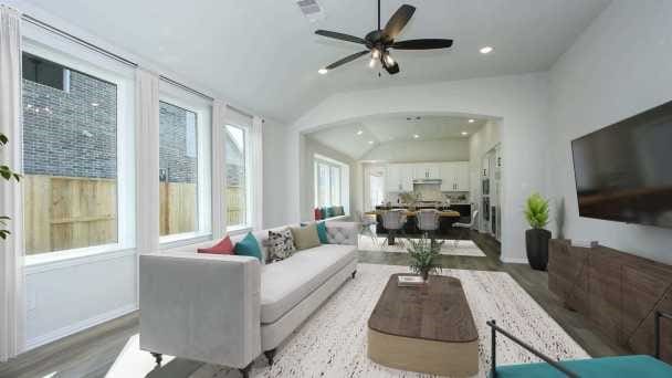 living room with hardwood / wood-style flooring, ceiling fan, and lofted ceiling