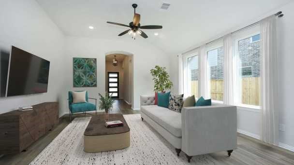 living room with ceiling fan, light hardwood / wood-style flooring, and lofted ceiling