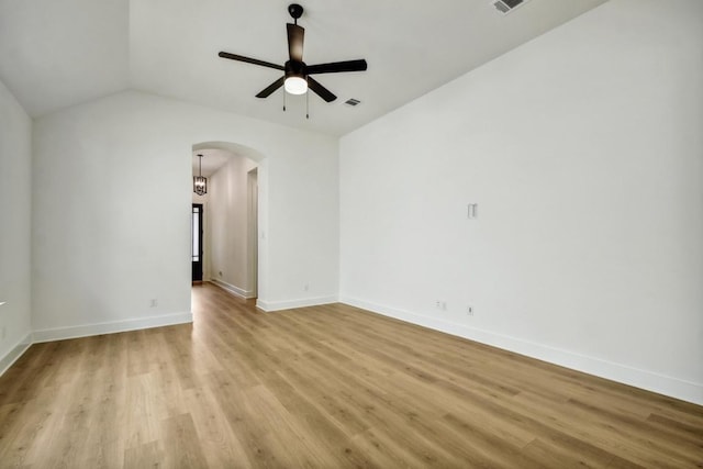 192 Bay Breeze Dr, Kyle, TX 78640 - empty room featuring arched walkways, a ceiling fan, light wood finished floors, baseboards, and vaulted ceiling
