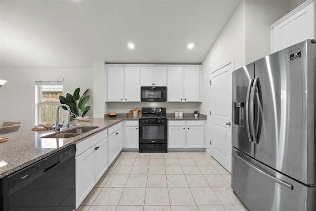 14121 Fallsprings Way, Manor, TX 78653 - kitchen with black appliances, white cabinetry, light tile patterned floors, stone counters, and recessed lighting