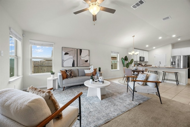 living room with lofted ceiling, sink, ceiling fan with notable chandelier, and light tile patterned floors