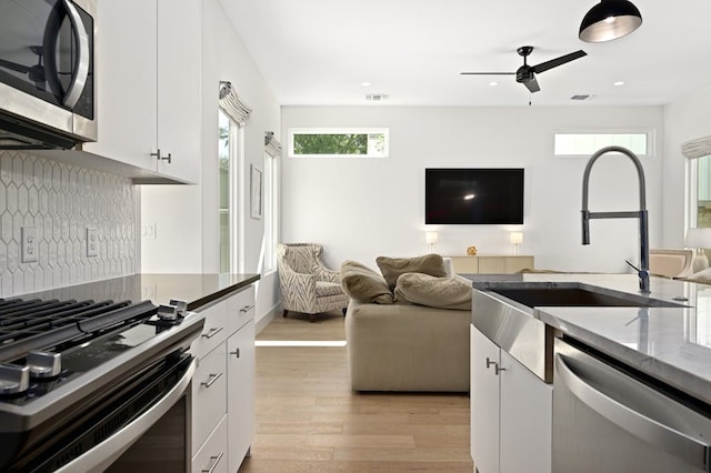 kitchen with white cabinetry, sink, stainless steel appliances, and light wood-type flooring