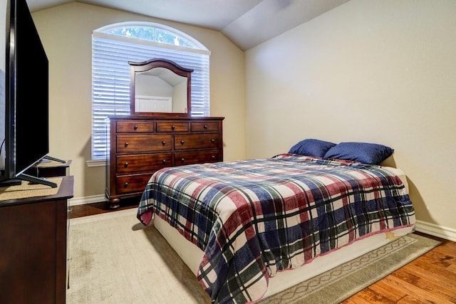 bedroom with multiple windows, light hardwood / wood-style flooring, and vaulted ceiling