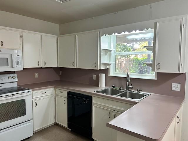 kitchen featuring white cabinetry, sink, and white appliances