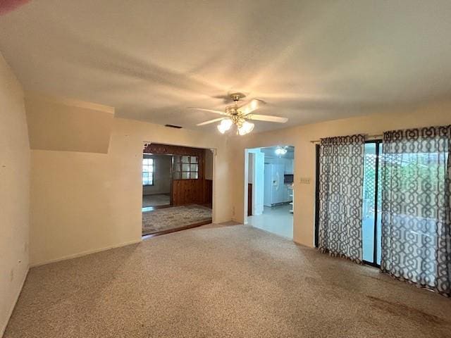 carpeted empty room with ceiling fan and a healthy amount of sunlight