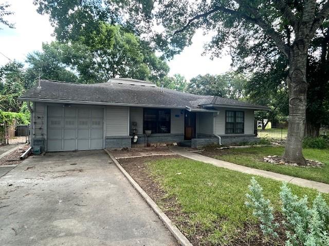 ranch-style home with a garage and a front yard