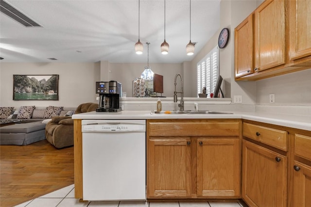 kitchen featuring sink, hanging light fixtures, kitchen peninsula, white dishwasher, and light tile patterned floors