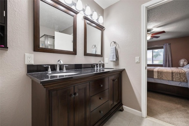 bathroom with tile patterned floors, ceiling fan, vanity, and a textured ceiling