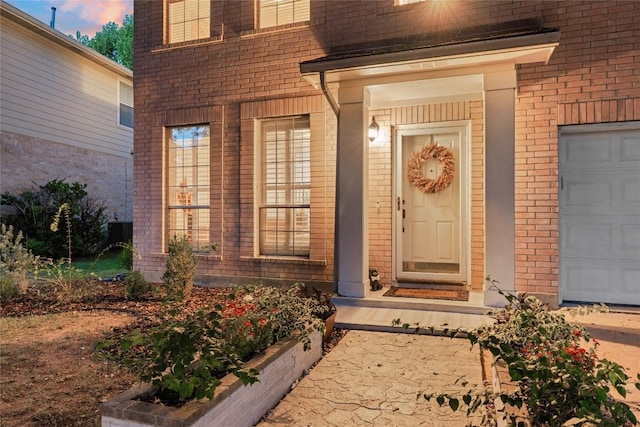 exterior entry at dusk featuring a garage