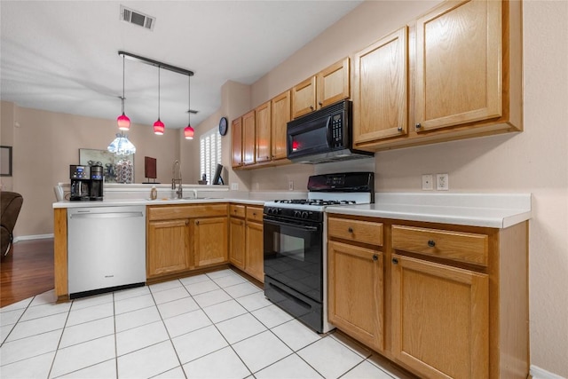 kitchen featuring pendant lighting, sink, light tile patterned floors, and black appliances