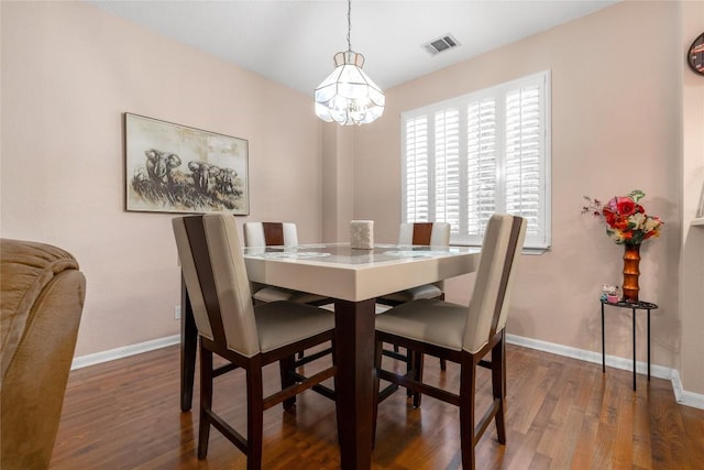 dining room featuring dark hardwood / wood-style floors and an inviting chandelier