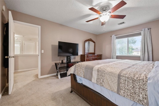 carpeted bedroom with ceiling fan and a textured ceiling