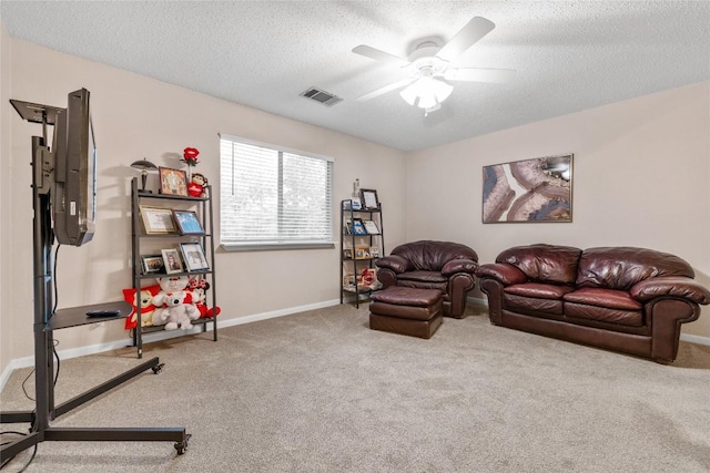 carpeted living room with ceiling fan and a textured ceiling