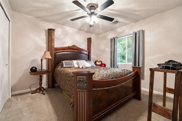 bedroom with a textured ceiling, ceiling fan, light carpet, and a closet