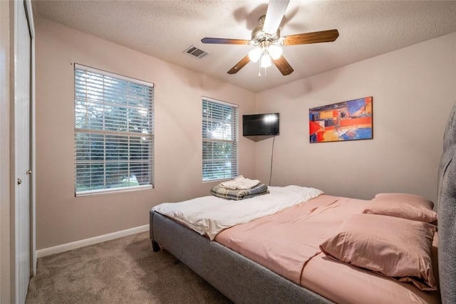 carpeted bedroom with a textured ceiling and ceiling fan