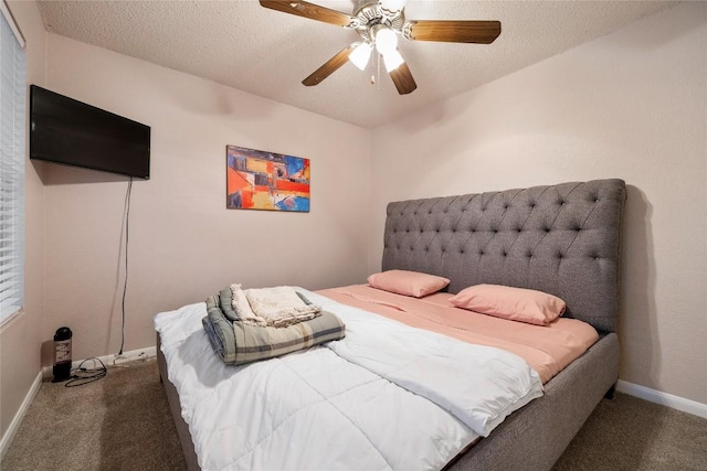 bedroom featuring dark colored carpet, a textured ceiling, and ceiling fan