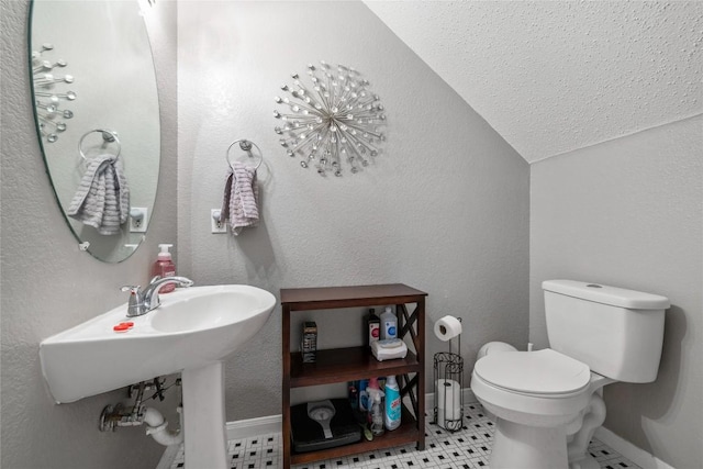 bathroom with tile patterned flooring, toilet, and vaulted ceiling