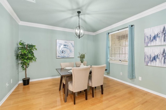 dining space with a notable chandelier, light wood-type flooring, and ornamental molding